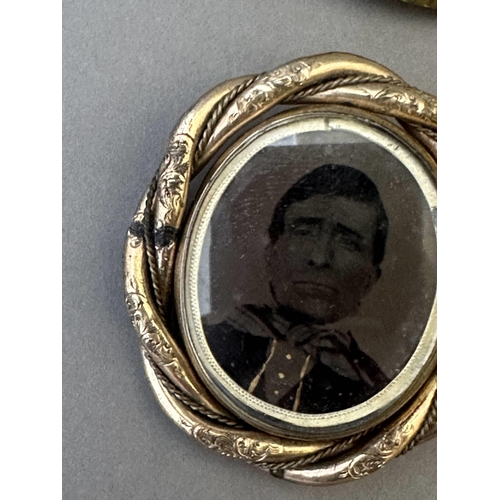 641 - Jewellery: Jewellery: A Victorian pinchbeck swivel brooch with a hand coloured photo of a young girl... 