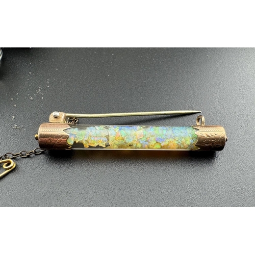 653 - Jewellery: Jewellery: An engraved yellow metal bar brooch, a central glass cylinder holding crushed ... 