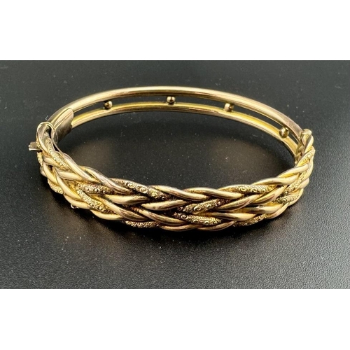 662 - Hallmarked Gold: Hallmarked Gold: A 9ct yellow gold hinged bangle, one half of rope twist design, th... 