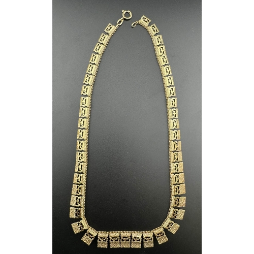 703 - Jewellery: Yellow metal Egyptian style necklace marked 9ct, with box. 22g. 42cm.