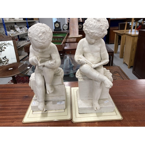 71 - Ceramics: A pair of painted plaster cherubs, one depicted reading, the other writing. 43cm and 41cm ... 