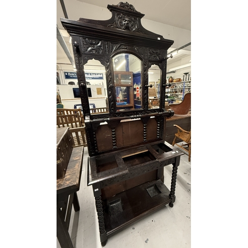 107 - Furniture: Furniture: 19th century dark oak mirrored hallstand heavily carved with leaf designs, lio... 