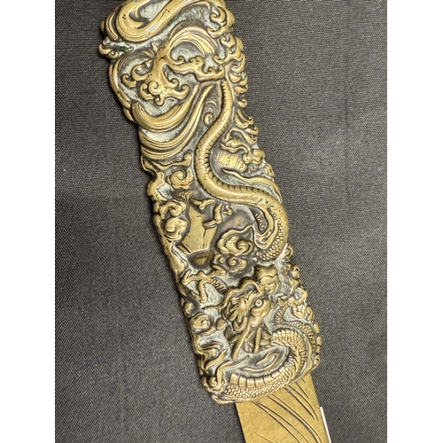 538a - Oriental: Oriental: A Japanese brass page turner, the handle decorated with a coiled dragon amongst ... 