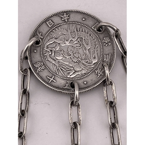 606 - Oriental Silver: Oriental Silver: A Chinese white metal coin, attached four chains as a chatelaine e... 