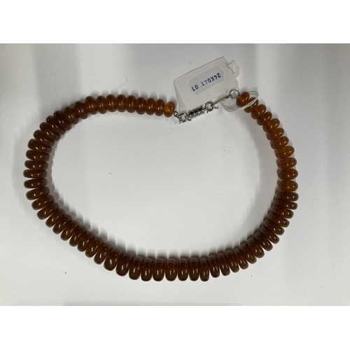 633 - Jewellery: Jewellery: A white metal clasped amber necklace, the flattened graduated beads ranging be... 