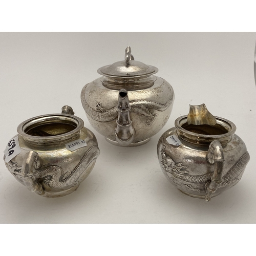 659a - Silver: Silver: A Chinese silver three piece tea set, each with all over planished decoration embell... 