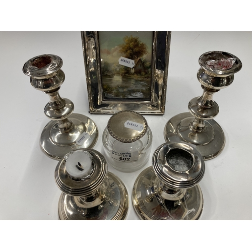 682 - Hallmarked Silver: Hallmarked Silver: Two pairs of silver candlesticks, a picture frame, and a silve... 