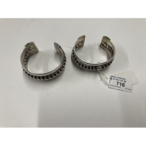 716 - Silver: Silver: Two Egyptian white metal torc bangles, with central chain decoration. Both bear earl... 