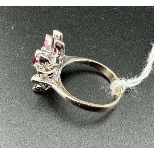 754 - Jewellery: Jewellery: A white metal ring, unmarked but testing as 14ct gold, set with nine rubies in... 