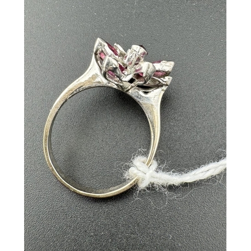 754 - Jewellery: Jewellery: A white metal ring, unmarked but testing as 14ct gold, set with nine rubies in... 