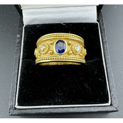 764 - Jewellery: Jewellery: A hand made yellow metal ring, testing as 18ct gold, set an oval sapphire betw... 