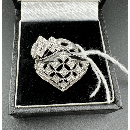 781 - Jewellery: Jewellery: A 9ct white gold ring of latticework form, the table set with several small di... 