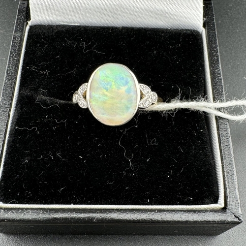 784 - Jewellery: Jewellery: A yellow metal ring, marked 18ct and testing as such, set an oval opal flanked... 