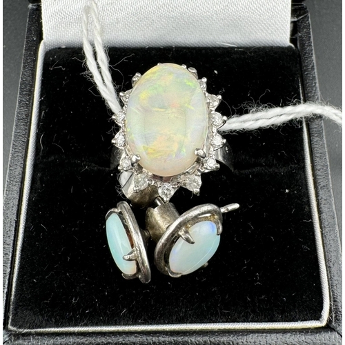 787 - Jewellery: Jewellery: A white metal ring, marked 18k and tests as 18ct gold, set with a central opal... 