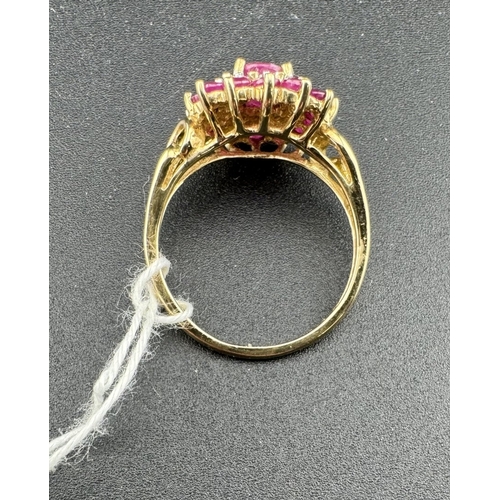 806 - Jewellery: Jewellery: A 9ct gold target style ring set with a central enhanced ruby within a ring of... 