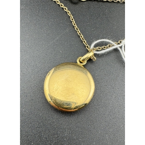 822 - Jewellery: Jewellery: A round yellow metal locket, marked '18' to the bale and testing as 18ct gold,... 