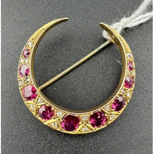 875 - Jewellery: Jewellery: A yellow metal (tests 9ct) crescent brooch set a ring of graduated rubies, the... 