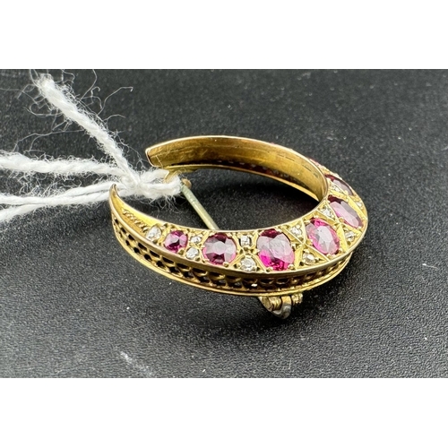 875 - Jewellery: Jewellery: A yellow metal (tests 9ct) crescent brooch set a ring of graduated rubies, the... 