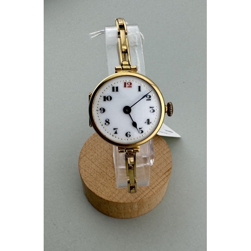 900 - Watches: Watches: An 18ct yellow gold trench watch on 18ct gold strap, London 1919, with enamelled d... 