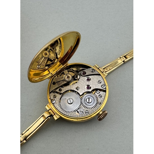 900 - Watches: Watches: An 18ct yellow gold trench watch on 18ct gold strap, London 1919, with enamelled d... 