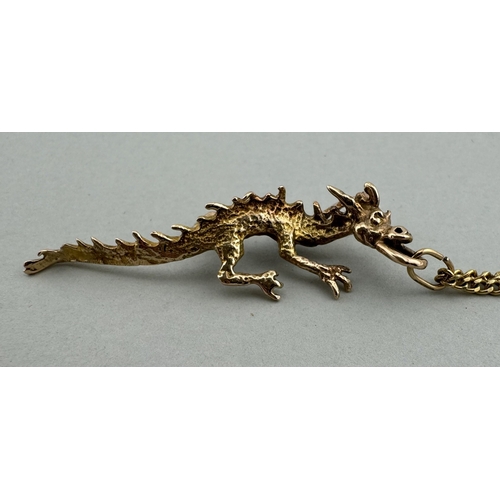 909 - Jewellery: Jewellery: A 9ct gold dragon pendant, depicted walking on all fours, 5.4g, on a gold plat... 