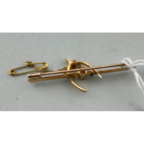 912 - Jewellery: Jewellery: A 15ct yellow gold bar brooch, set a central diamond within a stirrup. 4.6cm w... 