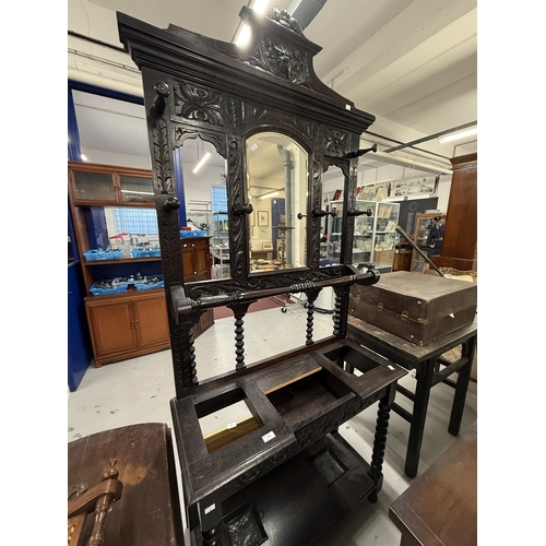 119 - Furniture: 19th century dark oak mirrored hallstand heavily carved with leaf designs, lion head pedi... 