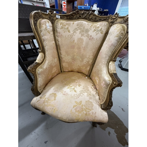 143 - Furniture: 18th century giltwood upholstered wingback chair elaborately carved, upholstered in an iv... 