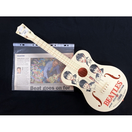 396 - Beatles Memorabilia: A Selcol Beatles toy New Sound Guitar c1965, the cream front face is printed wi... 