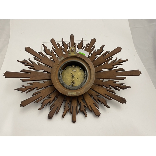 550 - Clocks: A French painted and giltwood sunburst effect wall clock, the enamelled dial with Roman nume... 