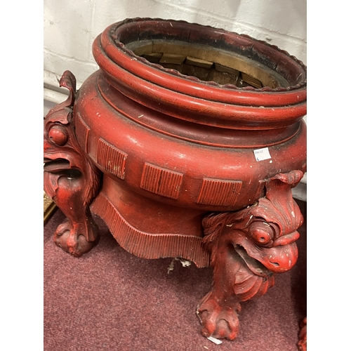 593 - Oriental: Early 20th century red painted treen, decorated with carved dragon heads on three supports... 