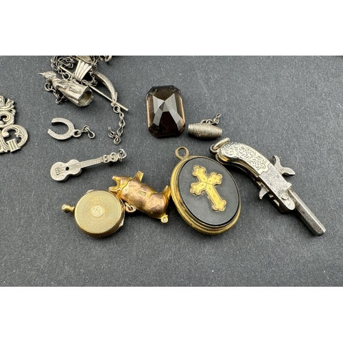 675 - Jewellery: A 9ct gold hollow pig charm, 0.7g; a yellow metal pocket watch style locket charm; an ony... 