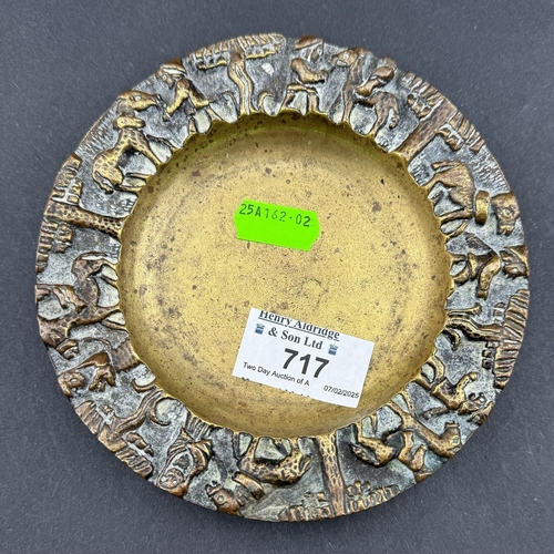 717 - Metalware: An early 20th century bronze pin dish, probably Indian, decorated to the rim in high reli... 