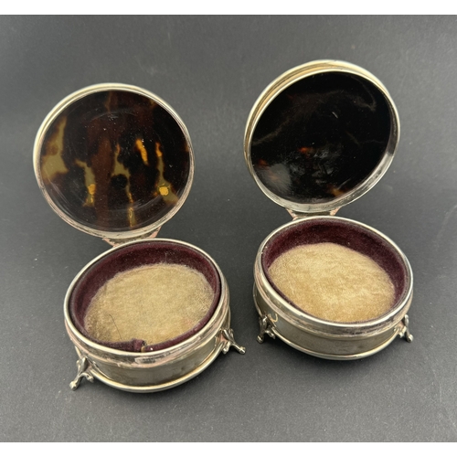 799 - Silver: Pair of circular tortoiseshell lids inlaid with silver pique work with a raised border, both... 