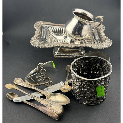 830 - Silver: A pierced bottle sleeve, a bangle made from a fork, two white metal bracelets, a Sheffield P... 