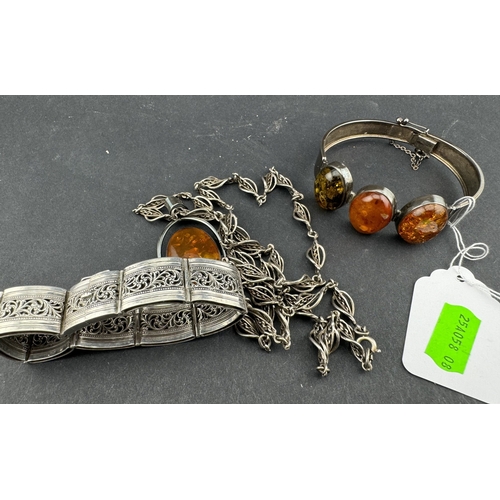 841 - Jewellery: A white metal (test as silver) and reconstituted amber bracelet, with matching pendant; a... 