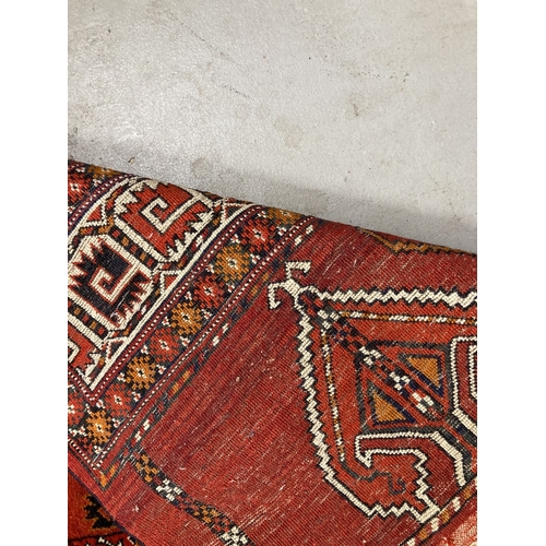 92 - Carpets/Rugs: Red ground afghan rug, hatched design with woven fringe.