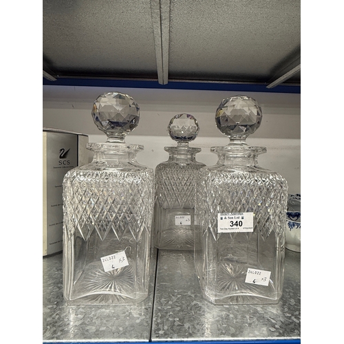 340 - Glass/Ceramics: Early 20th century trio of cut glass decanters of square form. Height 25cm.