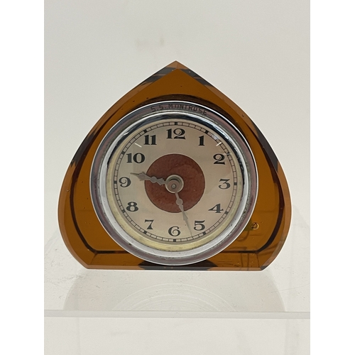 Clocks: An early 20th century triangular amber glass cased desk clock ...