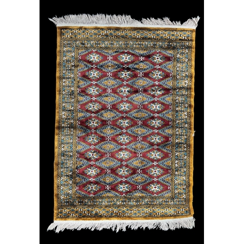6 - Rugs: a 20th C Bokhara rug, deep red diamonds within a light brown and blue border, approximately 14... 