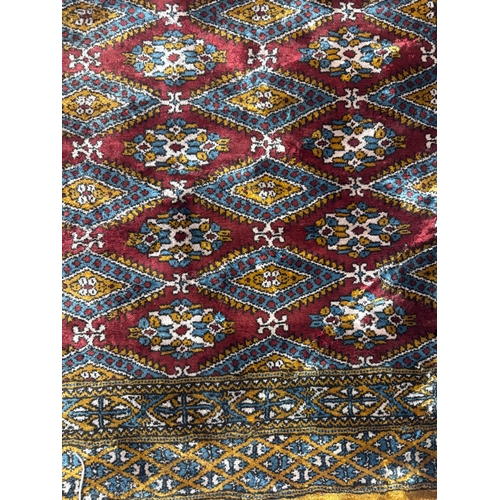 8 - Rugs: a 20th century Bokhara rug, deep red diamonds within a pale brown and blue hatched border. App... 