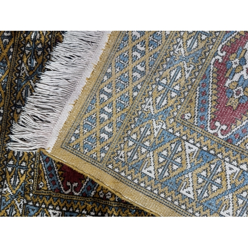 8 - Rugs: a 20th century Bokhara rug, deep red diamonds within a pale brown and blue hatched border. App... 