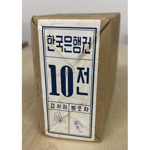 110 - 1962 a sealed packet of a thousand Bank of Korea 10 Jeon uncirculated banknotes