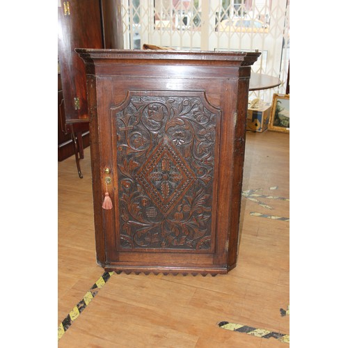 195 - A 19th century oak hanging corner cupboard with carved door, 80cm wide.