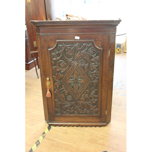 195 - A 19th century oak hanging corner cupboard with carved door, 80cm wide.