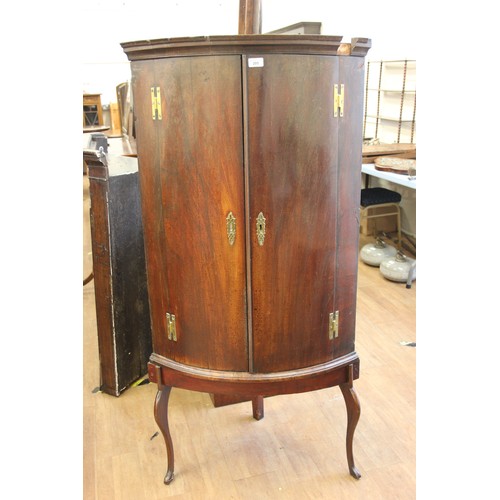 197 - A mahogany bow-fronted corner cupboard, now freestanding on three legged base, 70cm wide x 143cm hig... 