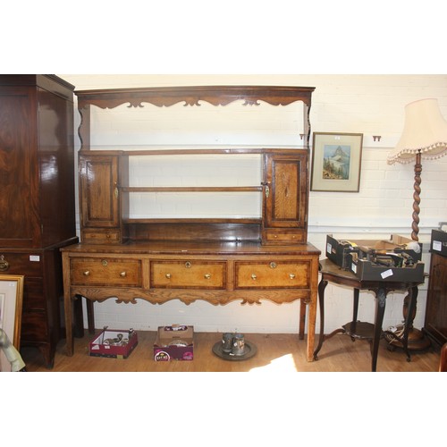 238 - A George III oak Shropshire dresser, the open rack flanked by two panelled doors, and spice drawers,... 