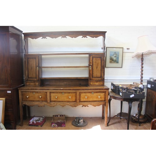 238 - A George III oak Shropshire dresser, the open rack flanked by two panelled doors, and spice drawers,... 