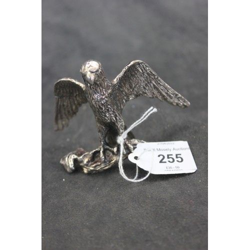 255 - A silver-plated figure of a hawk, on a branch, 7.5cm high.