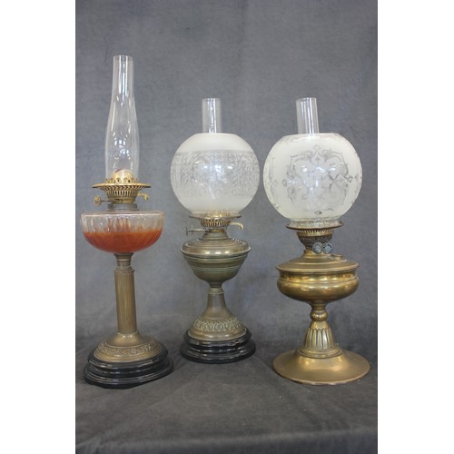 296 - Three Victorian and later brass oil lamps, with chimneys and shades (3).